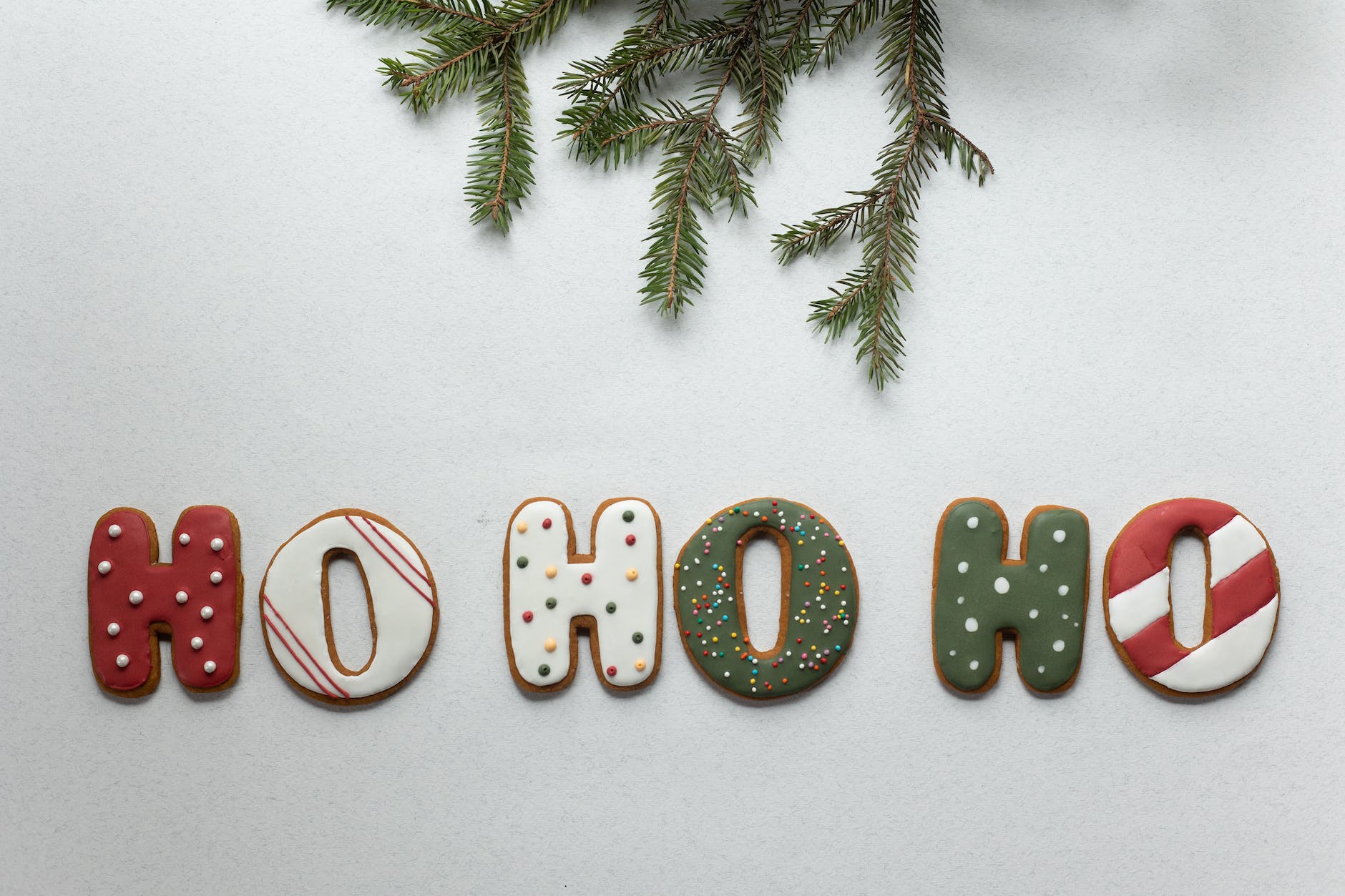 set of christmas sweets arranged with spruce twig on white table